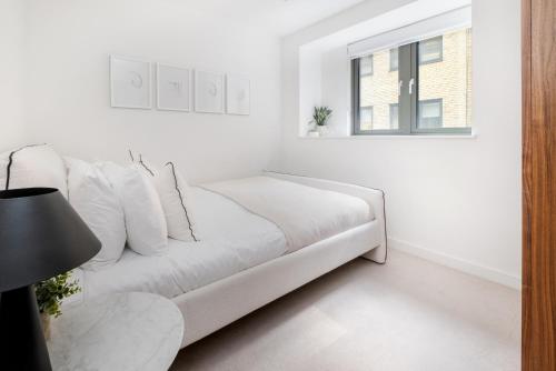 a white living room with a white couch and a window at Luxury Central Mayfair Townhouse with AC 3BR 3BA in London