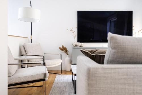a living room with two chairs and a tv at Luxury Central Mayfair Townhouse with AC 3BR 3BA in London