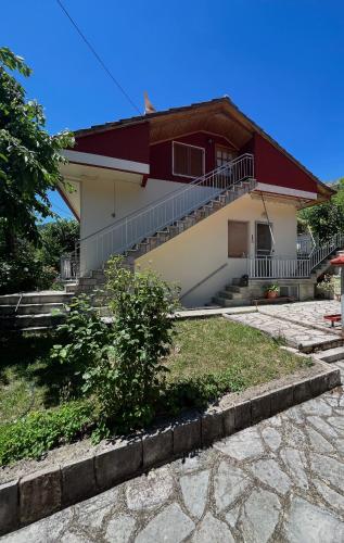 uma casa com uma escada em frente em Memories Apartments - Σοφίτα με τζάκι στο Καρπενήσι. em Karpenision