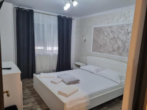 ein Schlafzimmer mit einem weißen Bett und einem Fenster in der Unterkunft CasaRiana 1 in Eforie Sud