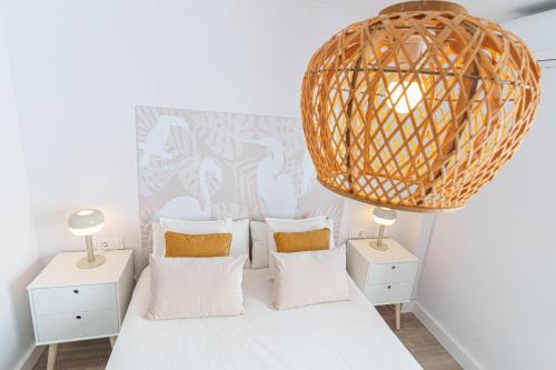 a bedroom with a bed with two night stands and a wicker at Casa Arai en Casco Histórico con Parking Gratuito in Ronda