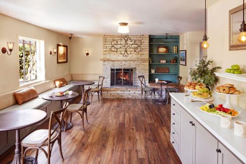 a kitchen with tables and chairs and a fireplace at Coachman's Inn, A Four Sisters Inn in Carmel