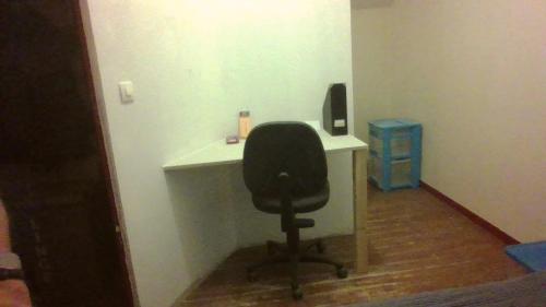 una silla negra sentada en un escritorio en una habitación en Chambre dans maison, en Betton
