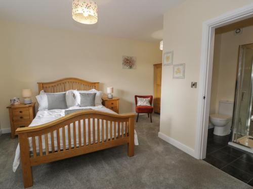 1 dormitorio con cama de madera y aseo en Tan Twr en Llanfairpwllgwyngyll