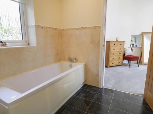 baño con bañera y ventana en Tan Twr en Llanfairpwllgwyngyll