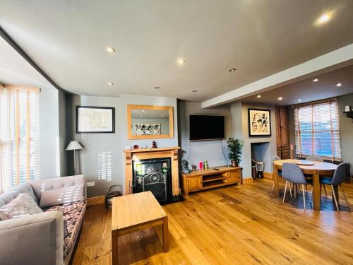 a living room with a couch and a fireplace and a table at Simpsons Cottage - Grove Road Cottages in Stratford-upon-Avon