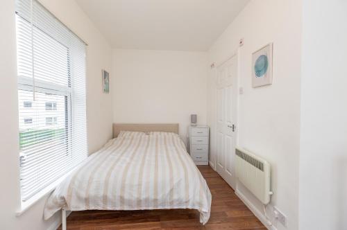 a white bedroom with a bed and a window at 33 Stanley Road in Northampton