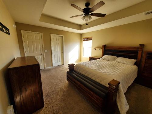 a bedroom with a bed and a ceiling fan at Master Bed & Bath Just For You in Bentonville