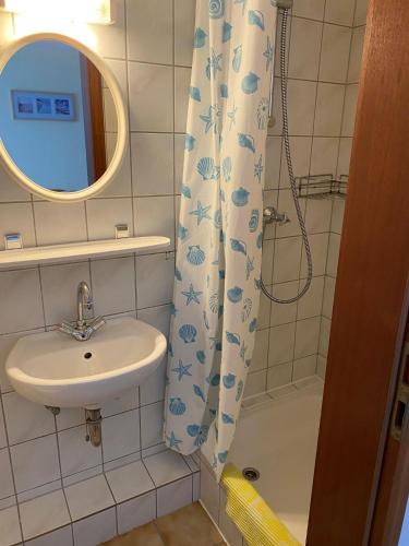 baño con lavabo y cortina de ducha en Pension Feist Zimmer 11 en Dagebüll