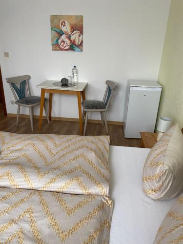 una camera con letto, tavolo e sedie di Pension Feist Zimmer 11 a Dagebüll