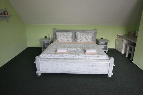 a bedroom with a white bed in a green room at Penzion Na Statku in Starý Vestec
