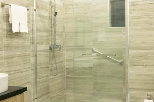 a shower with a glass door in a bathroom at Royale Escape in Cardiff Hall