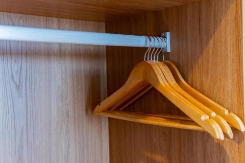 a wooden hanger hanging from a wooden wall at Atrium Studios by Xtay – Estúdios modernos, bem localizados e a 9min da Arena Opus in Palhoça
