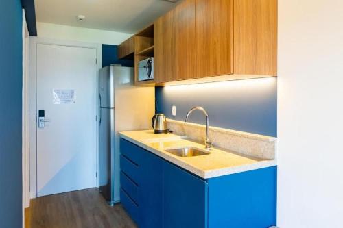 a kitchen with a sink and a refrigerator at Atrium Studios by Xtay – Estúdios modernos, bem localizados e a 9min da Arena Opus in Palhoça
