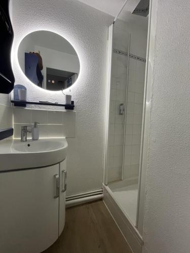 une salle de bain avec un lavabo et une douche avec un miroir dans l'établissement appartement cocon à Quiberon dans résidence calme, plages et centre ville à pied ou à vélo pour 2 à 4 personnes, à Quiberon