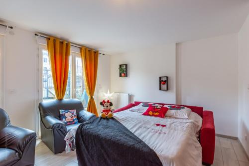 a bedroom with a large bed and a chair at Bienvenue chez Mickey ! in Montévrain