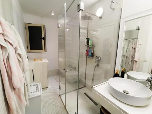 een witte badkamer met een wastafel en een douche bij SUNNY House in Tirana
