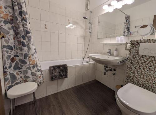łazienka z umywalką, toaletą i wanną w obiekcie Ferienwohnung Margareta w mieście Bad Goisern
