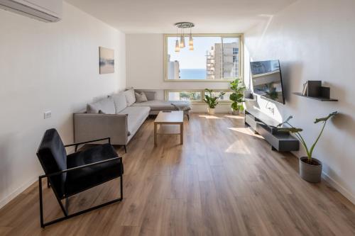 a living room with a couch and a tv at Roof Top 3 Floors in Netanya