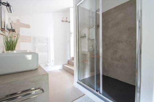 a bathroom with a glass shower and a sink at Chambre d'hôtes Les Cyprès de l'île in Avignon