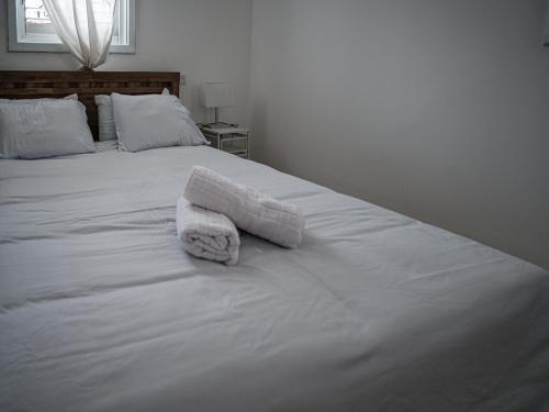 a white bed with two towels on top of it at Appartement cosy sur Netanya in Netanya