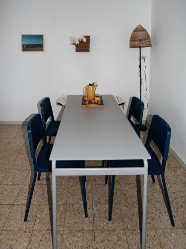 a white table with chairs and a floor lamp at Appartement cosy sur Netanya in Netanya