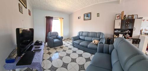 sala de estar con sofá azul y TV en Casa vacacional Villa San Lorenzo, en Tomatas