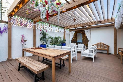 un patio con tavolo in legno e mobili bianchi di The Millwood a Millbrae