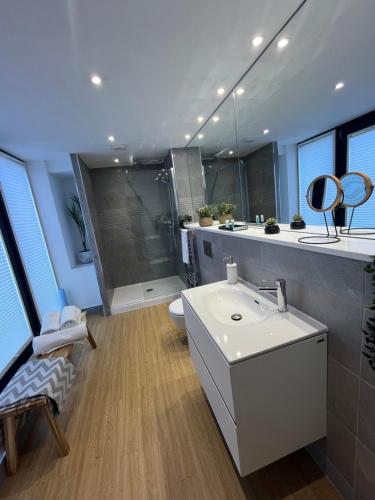 a bathroom with a white sink and a shower at Beachcliff Rooms & Apartments in Cardiff