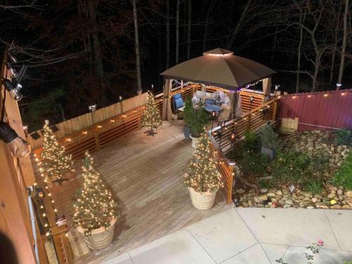 a wooden deck with christmas trees and an umbrella at Entire Apartment Suite family singles Couples Nurses dinners business meetings in Lithonia