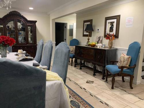 a living room with blue chairs and a table and a piano at Entire Apartment Suite family singles Couples Nurses dinners business meetings in Lithonia