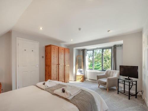 a bedroom with a large bed and a television at Northlands Farm - Old Farm Cottage in Chichester