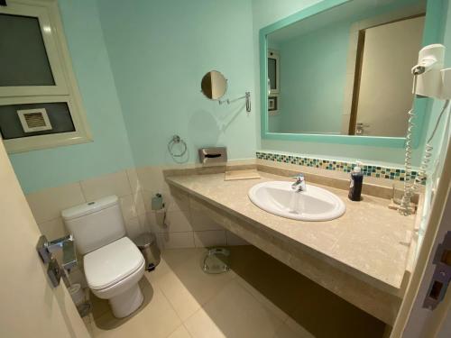 a bathroom with a toilet and a sink and a mirror at Byoum lake side hotel room, Tunis village, fayoum in Qaryat at Ta‘mīr as Siyāḩīyah