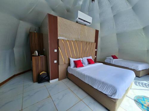 a bedroom with two beds with red pillows at European luxury camp in Disah