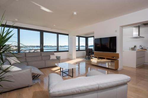 un soggiorno con mobili bianchi e una grande TV di Seafront Luxury Suite Idassa by Belmont Realty a Zara (Zadar)
