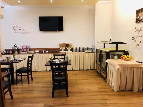 a restaurant with tables and a bar with a tv on the wall at Hotel am Ledermuseum in Offenbach