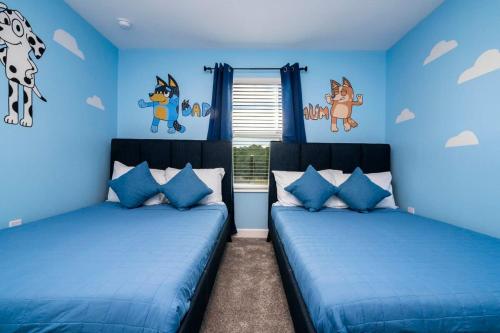 twee bedden in een slaapkamer met blauwe muren bij Marvelous 4Bd with Pool at Storey Lake Resort 2601 in Kissimmee