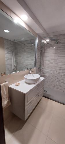 La salle de bains est pourvue d'un lavabo et d'un grand miroir. dans l'établissement Troia Setubal Praia, à Tróia