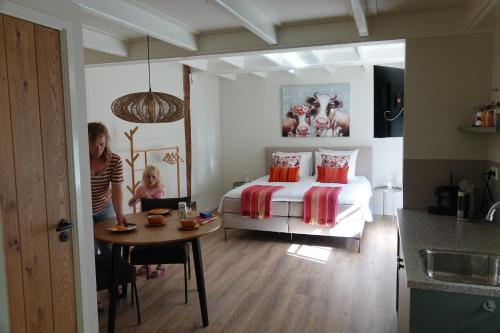 a woman and a child in a bedroom with a bed at Terras kamer in Spang