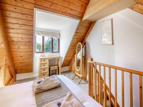 a bedroom in a log cabin with a bed and a desk at Northlands Farm Superior Chalet 1 in Chichester