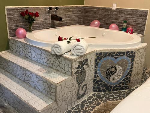 a bathroom with a tub with towels in it at Hokhmah Heart Hotel in Puerto Morelos