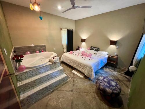 a bedroom with a bed and a bath tub at Hokhmah Heart Hotel in Puerto Morelos