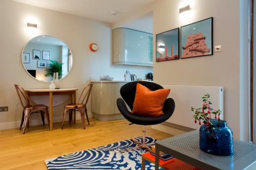 a living room with a chair and a table at Madison Hill - Byrne Garden 2 - One bedroom home in London