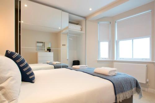 - une chambre avec 2 lits et un grand miroir dans l'établissement Madison Hill - Byrne Garden 2 - One bedroom home, à Londres