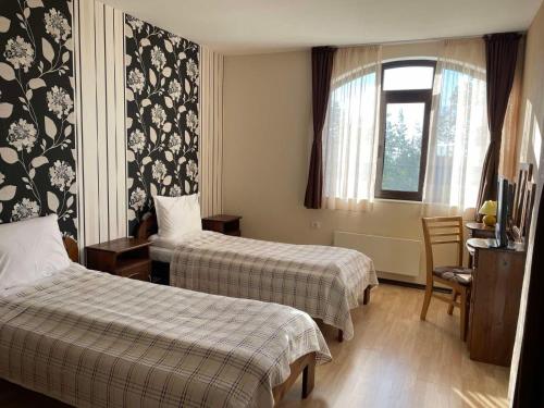 パンポロボにあるCassiopea Villasのベッド2台と窓が備わるホテルルームです。