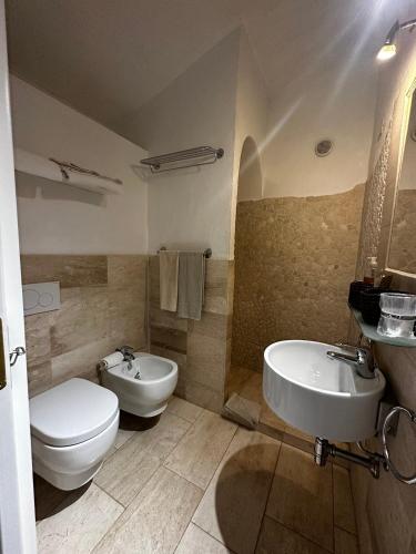 a bathroom with a toilet and a bidet and a sink at Antica Dimora La Corona in San Pantaleo