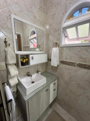 a bathroom with a sink and a mirror at Casa c/ bela vista para Baía Sul in Florianópolis
