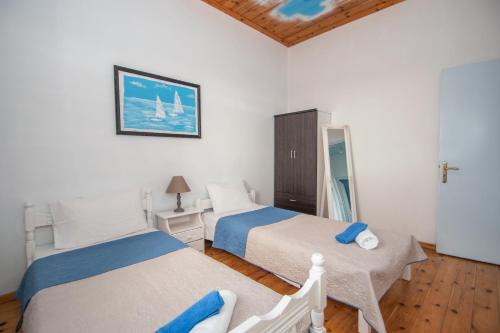 een slaapkamer met 2 bedden en een spiegel bij Villa Voula in Ágios Nikólaos