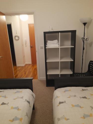 a bedroom with two beds and a book shelf at Glastonbury town center-entire apartment in Glastonbury