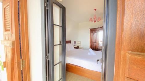 a bedroom with a bed and a sliding glass door at Cantinho da Ponta do Pargo in Ponta do Pargo